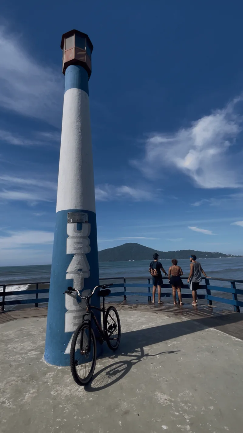 Farol do píer de Ubatuba com bicicleta e o mar ao fundo