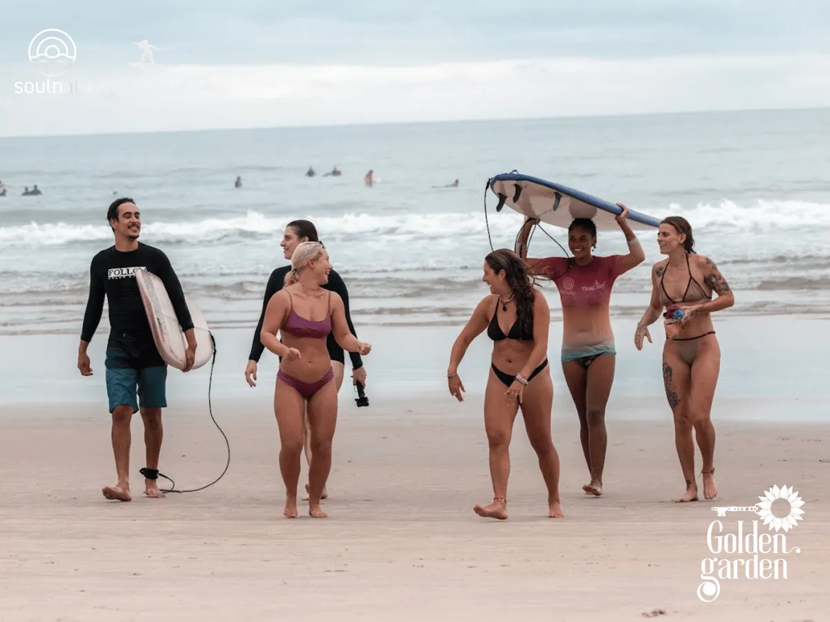 Turma saindo do mar com as pranchas