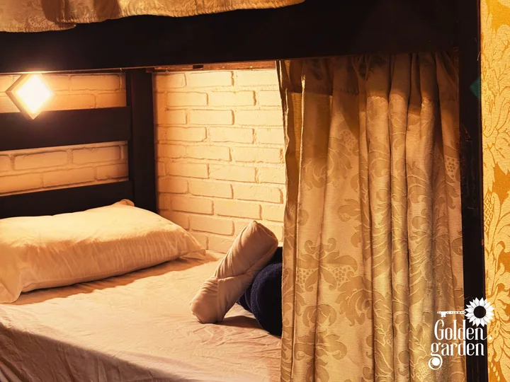 Quarto compartilhado com beliches e cortinas